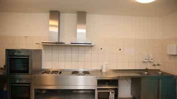 Eine moderne Küche mit Edelstahlgeräten, darunter ein Backofen, eine Mikrowelle und ein Herd, sowie ein Spülbecken.