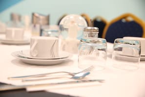 A table set with white plates, a white cup, two clear glasses, and a fork. - Twinhof (Hamburg)