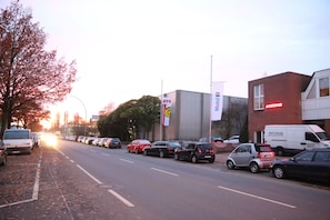 A street with parked cars and buildings, including a GTU Mobil sign. - Twinhof (Hamburg)