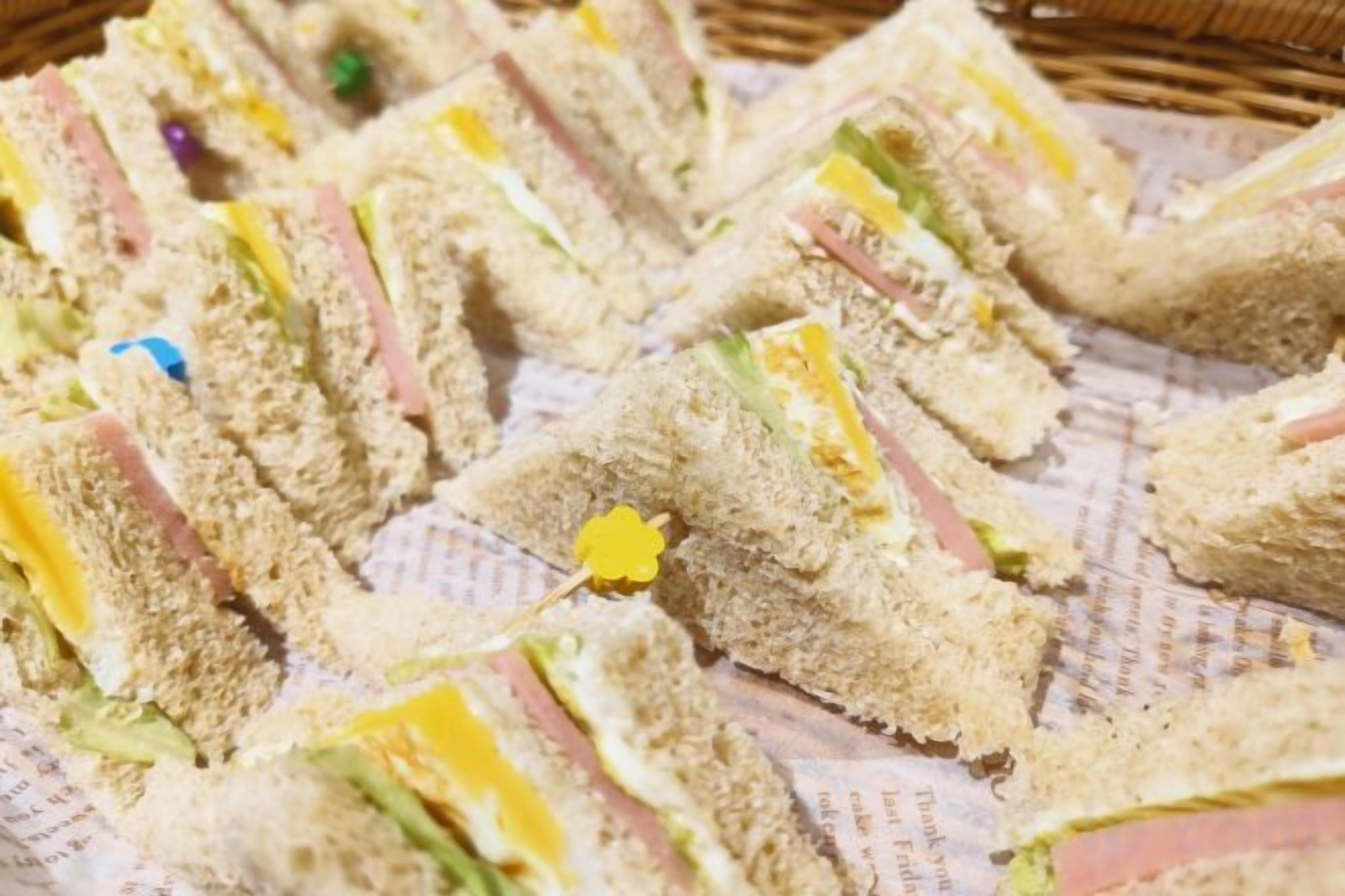Un plateau de sandwichs garnis de différentes façons, disposés sur une surface en papier.