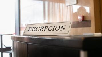 Un mostrador de recepción con un cartel que dice 'RECEPCION'.