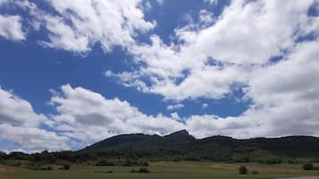 Un paisaje montañoso con cielo despejado y algunas nubes dispersas.