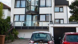 A modern two-story house with a garage, parked cars, and a cobblestone driveway. - Hotel Brunnenhof (Hanau)