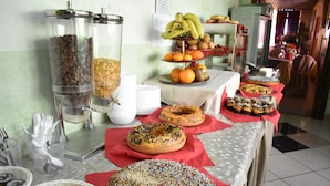Una mesa de buffet con distintos alimentos y recipientes.