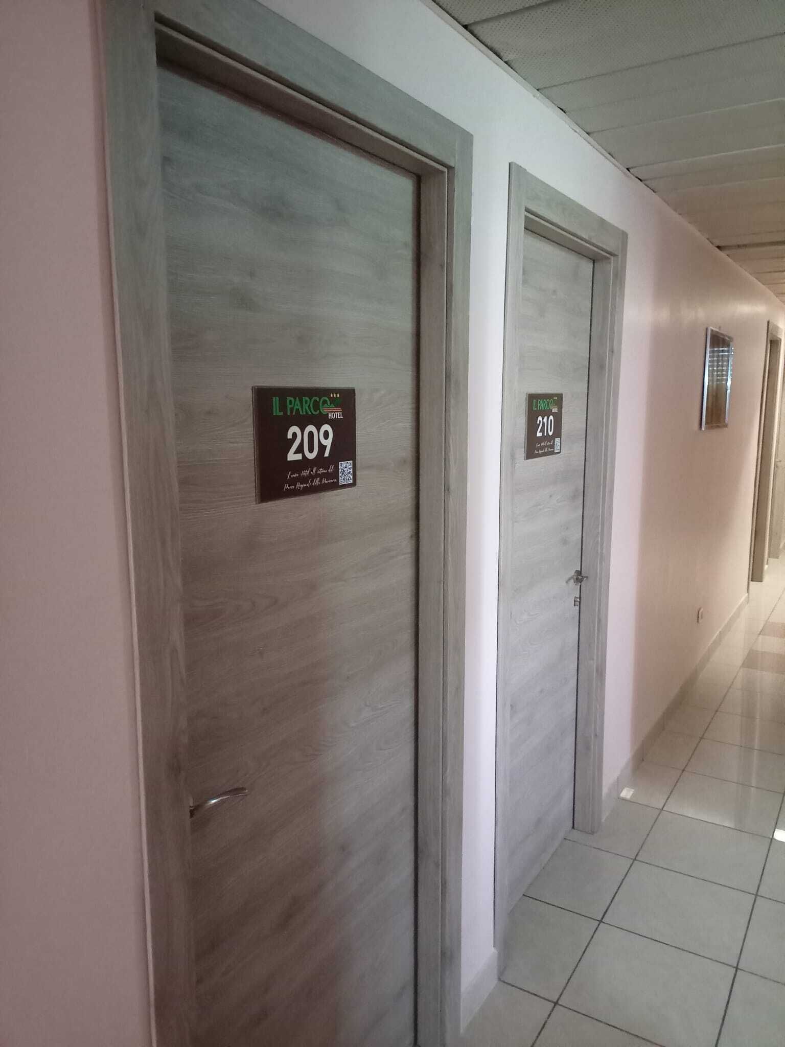 Un couloir d’hôtel avec des portes numérotées 209 et 210, indiquant les numéros des chambres.