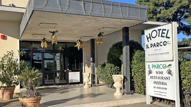 La entrada del Hotel Il Parco, con un cartel que indica que es restaurante de vinos y pizzería.