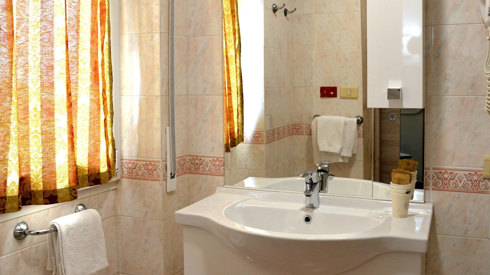 A bathroom with a sink, mirror, and towel rack.