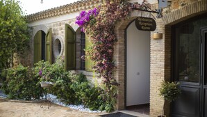 A building with a stone facade, a sign for 'Restaurant Reception Rooms', and a potted plant near the entrance. - Agriresort Leano (Piazza Armerina)