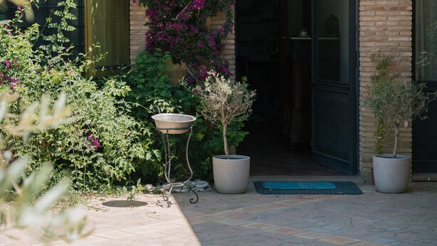 A building with a tiled roof, a doorway, and potted plants. - Agriresort Leano (Piazza Armerina)