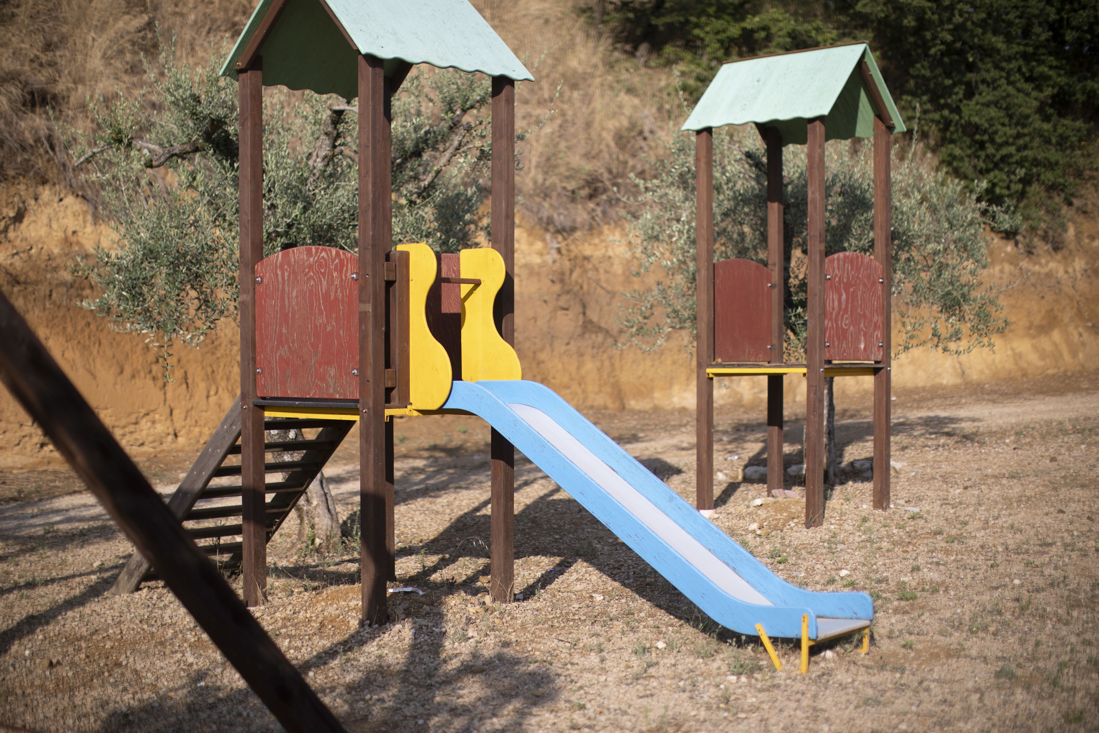 Une aire de jeux avec des structures en bois et un toboggan.