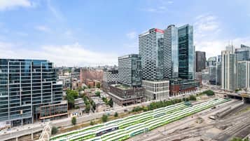 Un paisaje urbano moderno con edificios altos, un sistema de tranvías y un ambiente citadino concurrido.