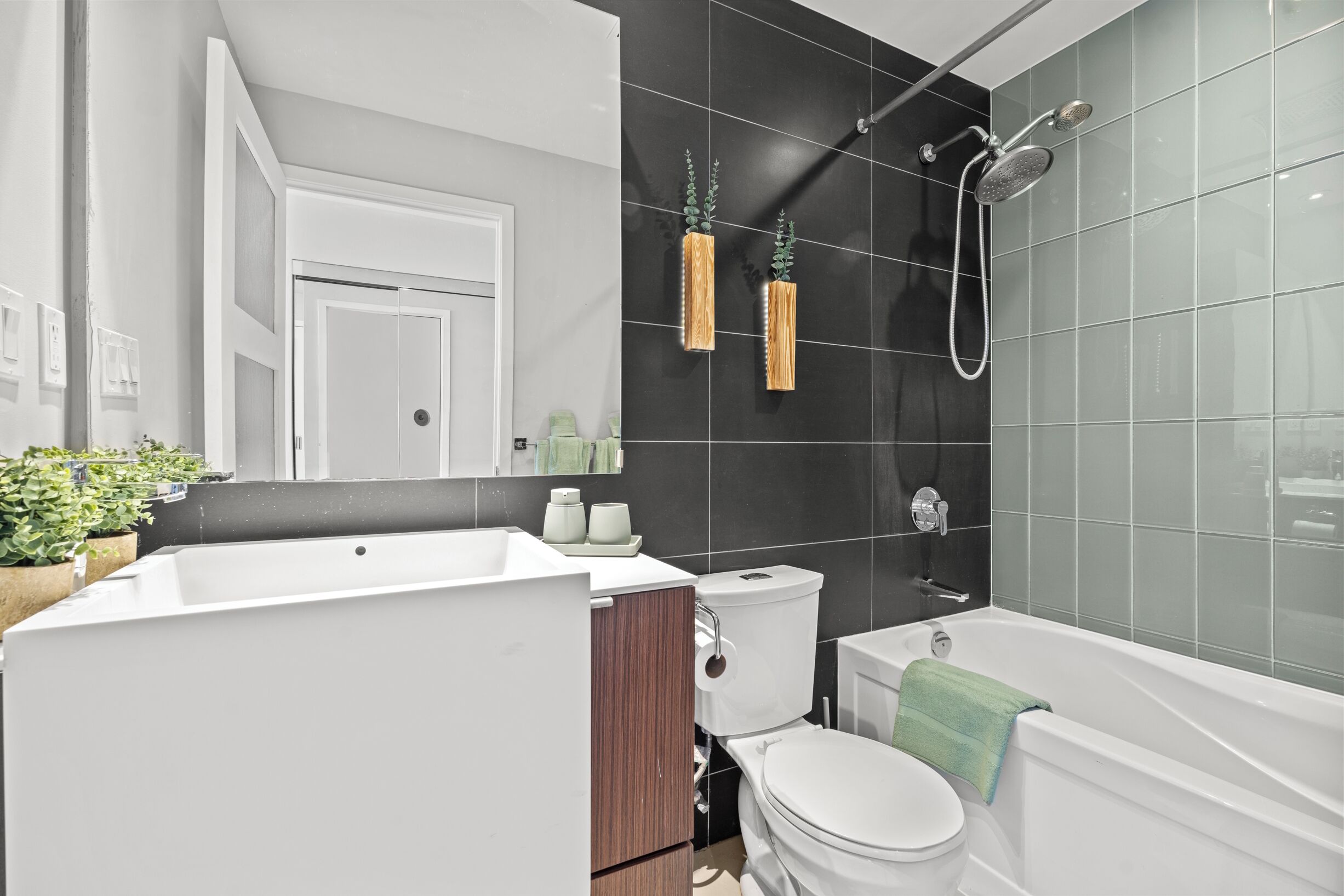 A modern bathroom with a bathtub, toilet, and sink.