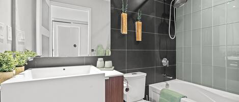A modern bathroom with a bathtub, toilet, and sink.