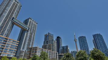 Un paisaje urbano con modernos rascacielos, incluyendo una torre distintiva con aguja.