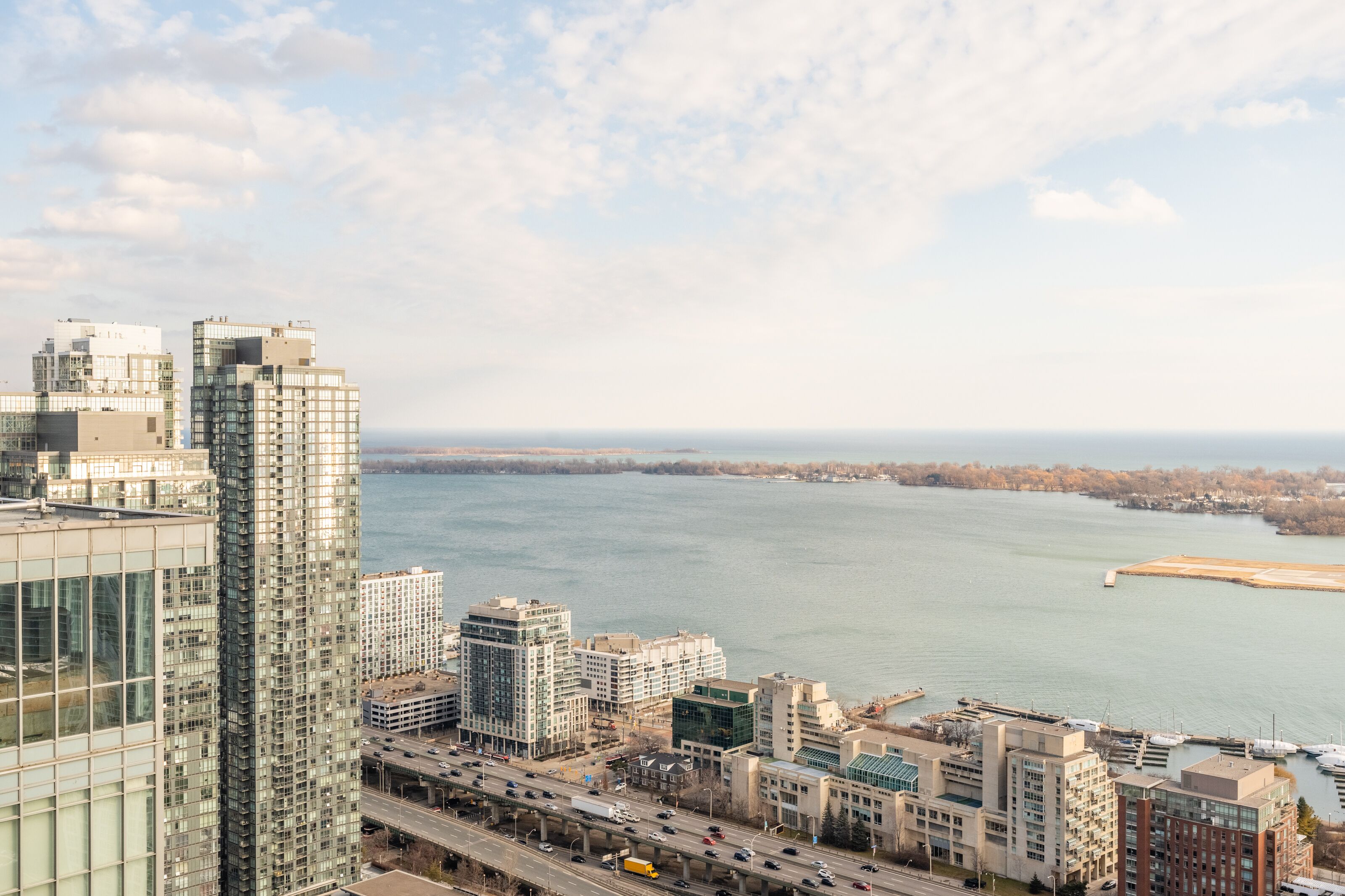 A high-rise building with a view of a river and distant city skyline.