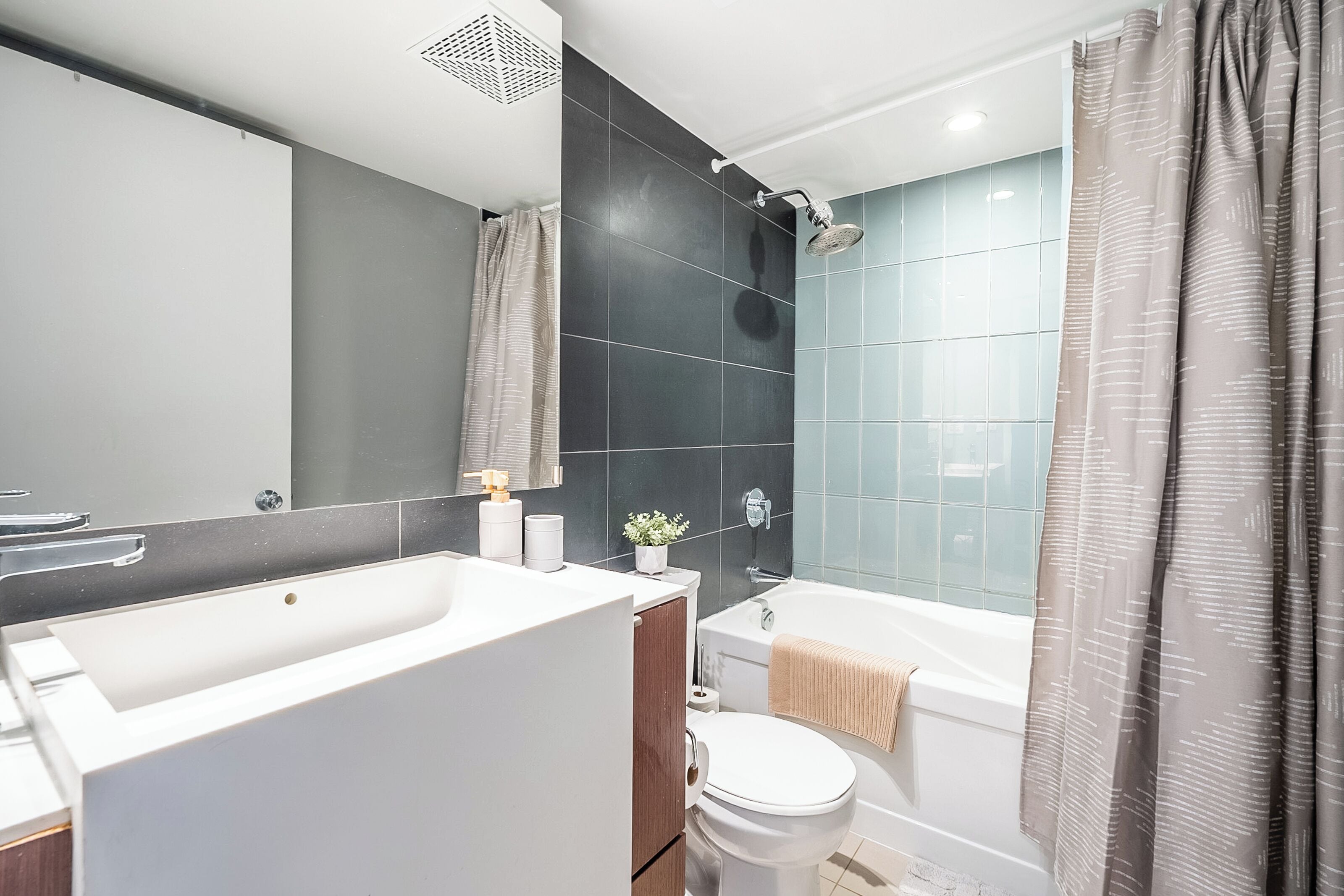 A modern bathroom with a bathtub, toilet, and sink.