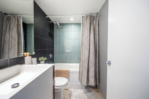 Een moderne badkamer met een badkuip, toilet en wastafel.