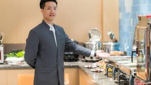 A person in a suit serving food from a buffet. - Home Inn Neo (Shanghai Xujiahui Wanping South Road) (Shanghai)