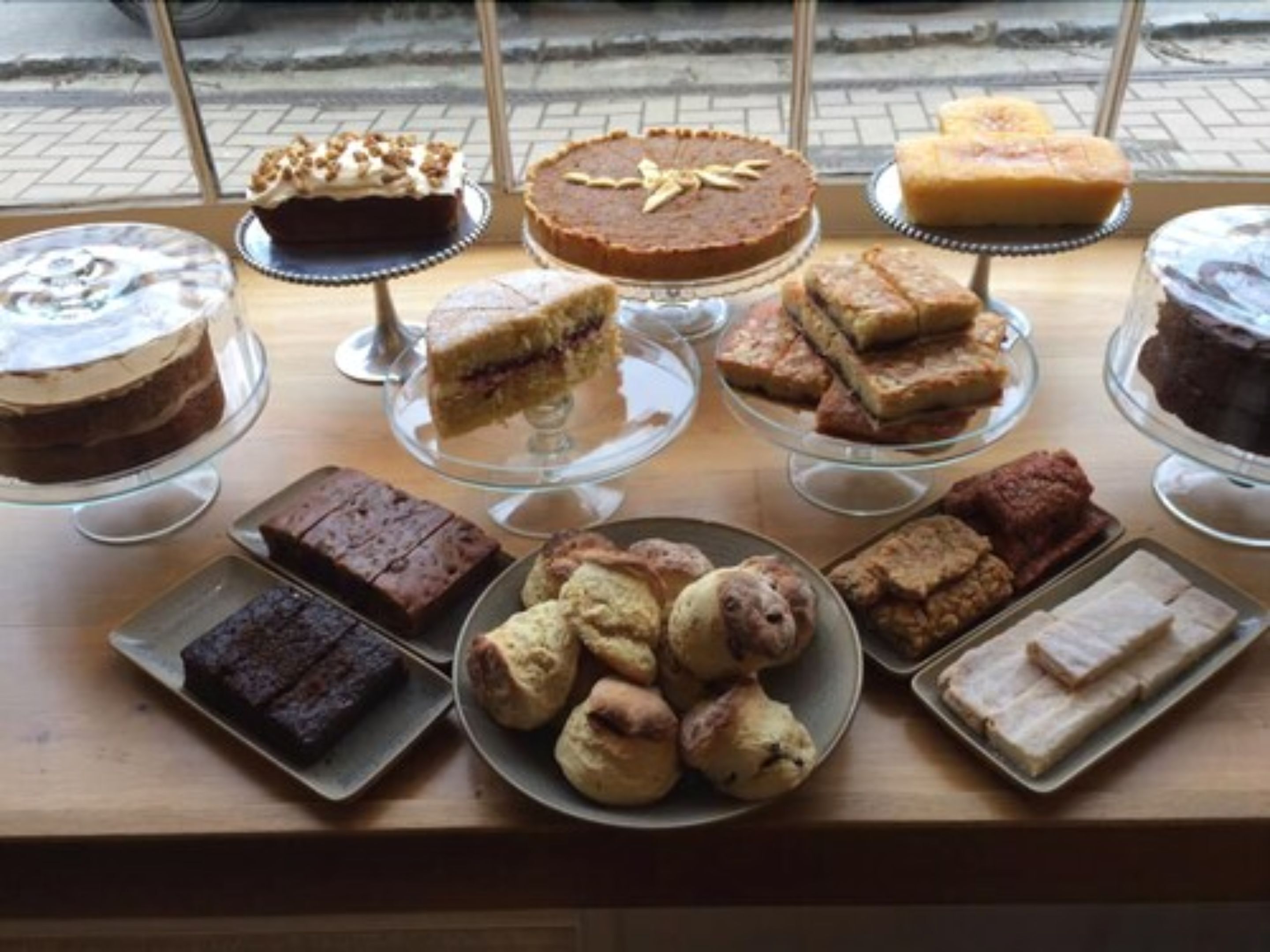 A variety of desserts displayed on a wooden table.