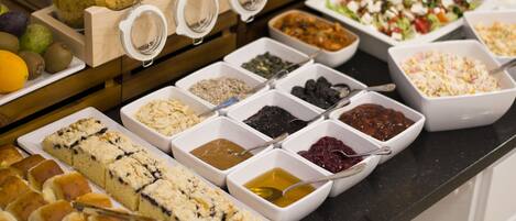 A buffet with various food items and condiments.