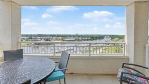 A balcony with a view of a marina and surrounding buildings.