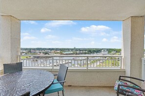 Een balkon met uitzicht op een jachthaven en omliggende gebouwen.
