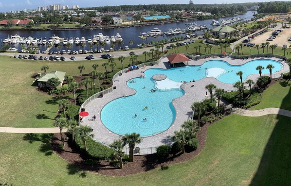 Un grand parc aquatique doté de nombreuses piscines, avec un port de plaisance en arrière-plan.