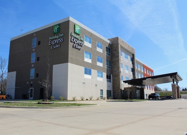 A Holiday Inn Express building with a modern design, featuring a mix of brick and concrete facades, multiple windows, and a covered entrance area.