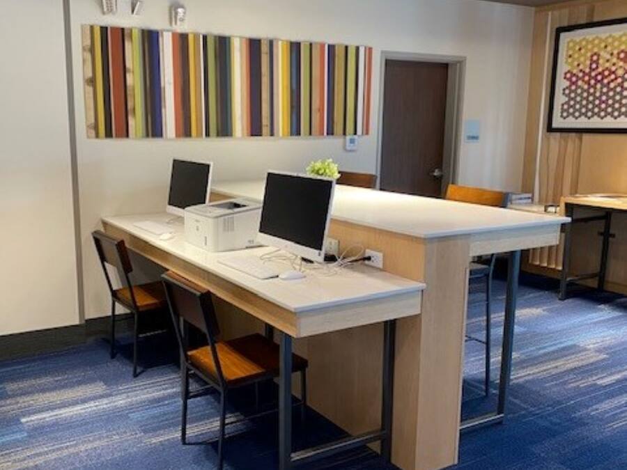 Une salle de conférence avec une longue table, deux ordinateurs et des chaises.