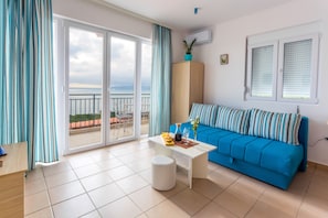 Relax in this stylish living room with a sofa, coffee table, and ottoman, plus a balcony just steps away.