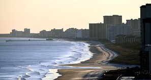 A coastal cityscape with a beach, high-rise buildings, and a pier. - Waipani E13 - 2BR Charming Condo! Across from Beach in Ocean Drive! (North Myrtle Beach)