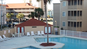 A swimming pool with multiple lanes, surrounded by lounge chairs and a small building with a red roof. - Waipani E13 - 2BR Charming Condo! Across from Beach in Ocean Drive! (North Myrtle Beach)
