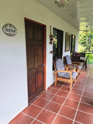 A covered porch with wooden doors and a sign reading "Casa de Campo".