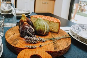 Ein Holzboden mit Feigen, Käse und Rosmarin auf einem Tisch.