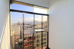 Overlooking the vibrant cityscape, this room offers a view of the urban area with residential and commercial buildings.