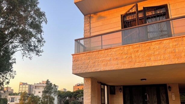 A modern two-story building with a balcony, a gated entrance, and potted plants. - Apartment in Jdeideh Beirut (Jdeideh)