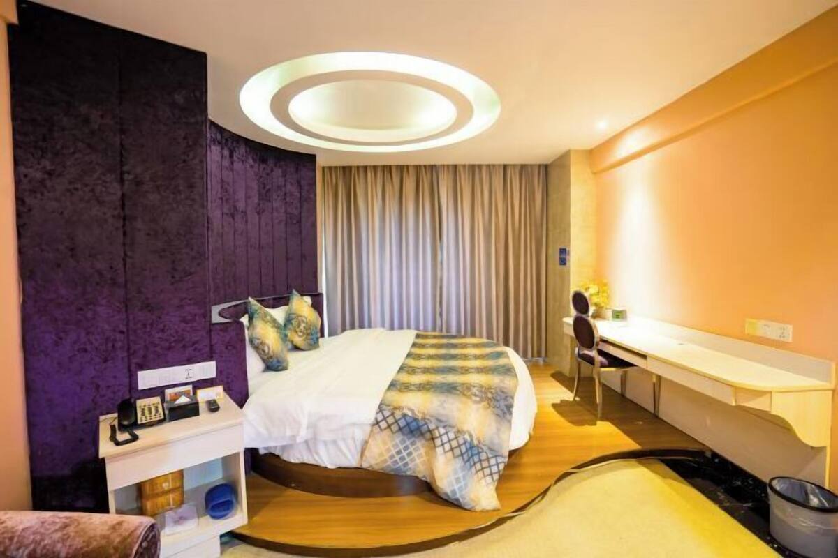 A modern hotel room with a bed, desk, and chair.