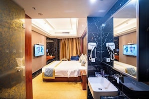 A hotel room with a bed, a large mirror, a sink, and a television. - Heng Rong Hotel (FANGCHENGGANG)