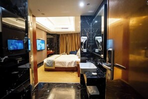 A hotel room with a bed, a large mirror, a television, and a bathroom with a sink and mirror. - Heng Rong Hotel (FANGCHENGGANG)