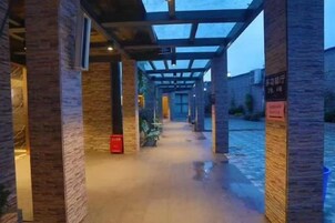 Un pasillo con paredes de ladrillo y estructura de techo de madera.