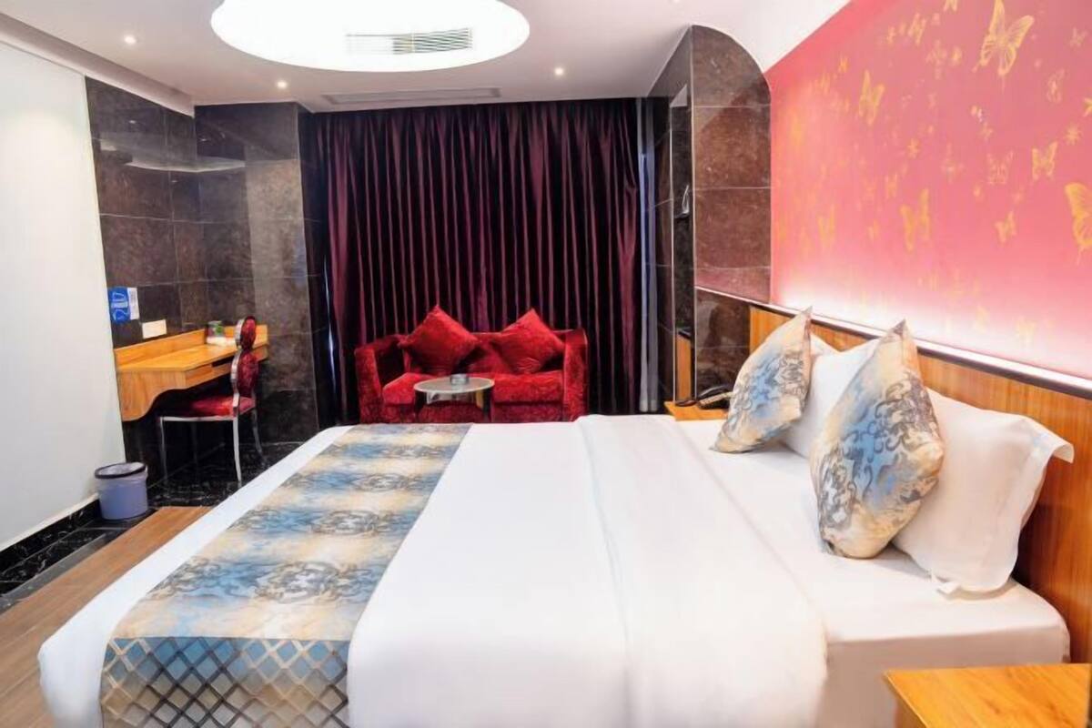 A hotel room with a bed, a desk, and a chair.