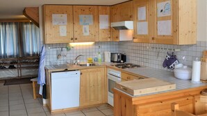 Una cucina con mobili in legno, lavastoviglie, piano cottura e lavello.