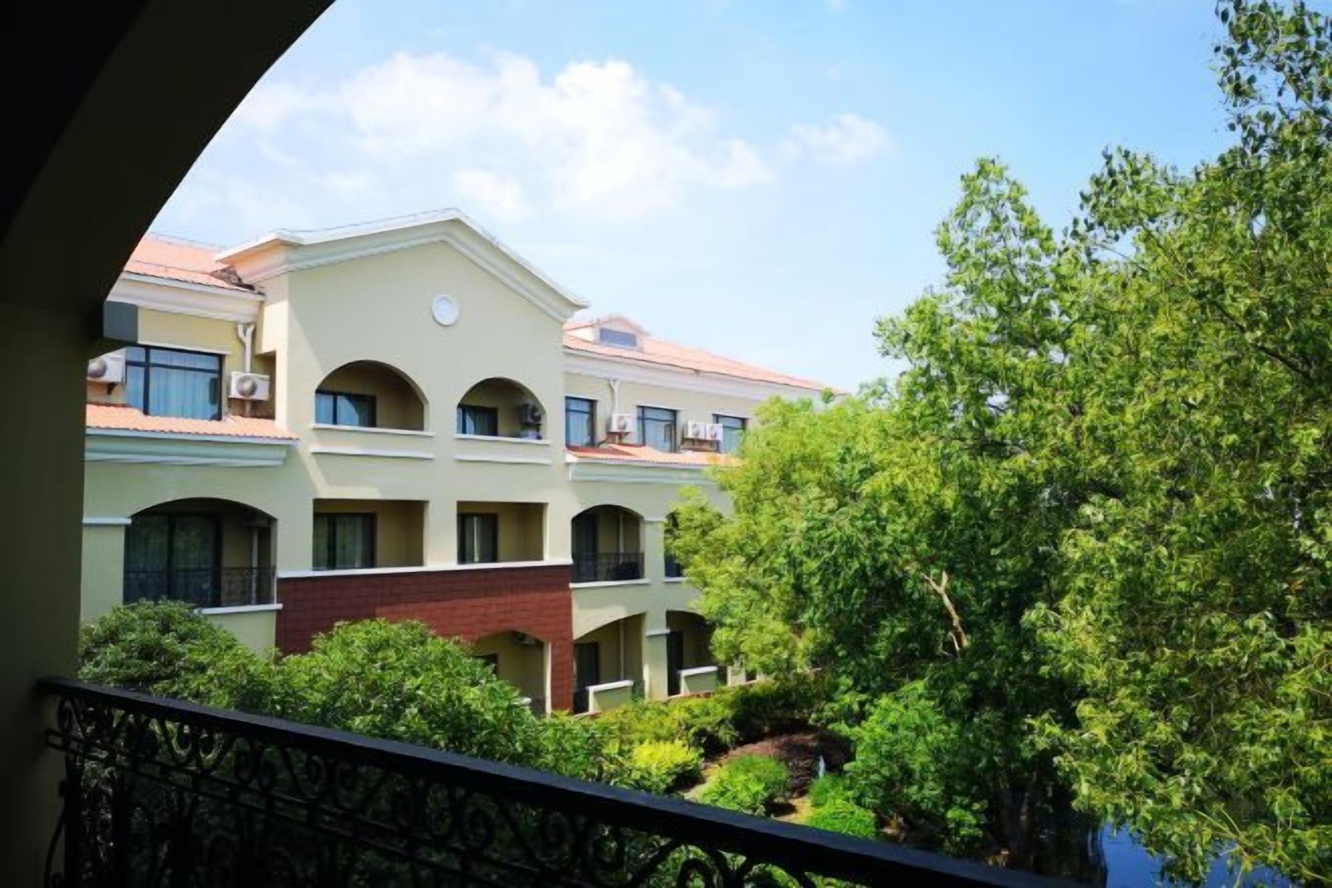 A multi-story building with a courtyard, balconies, and a clear sky.