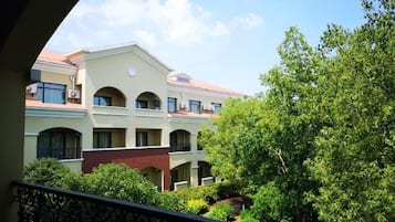 A multi-story building with a courtyard, balconies, and a clear sky.