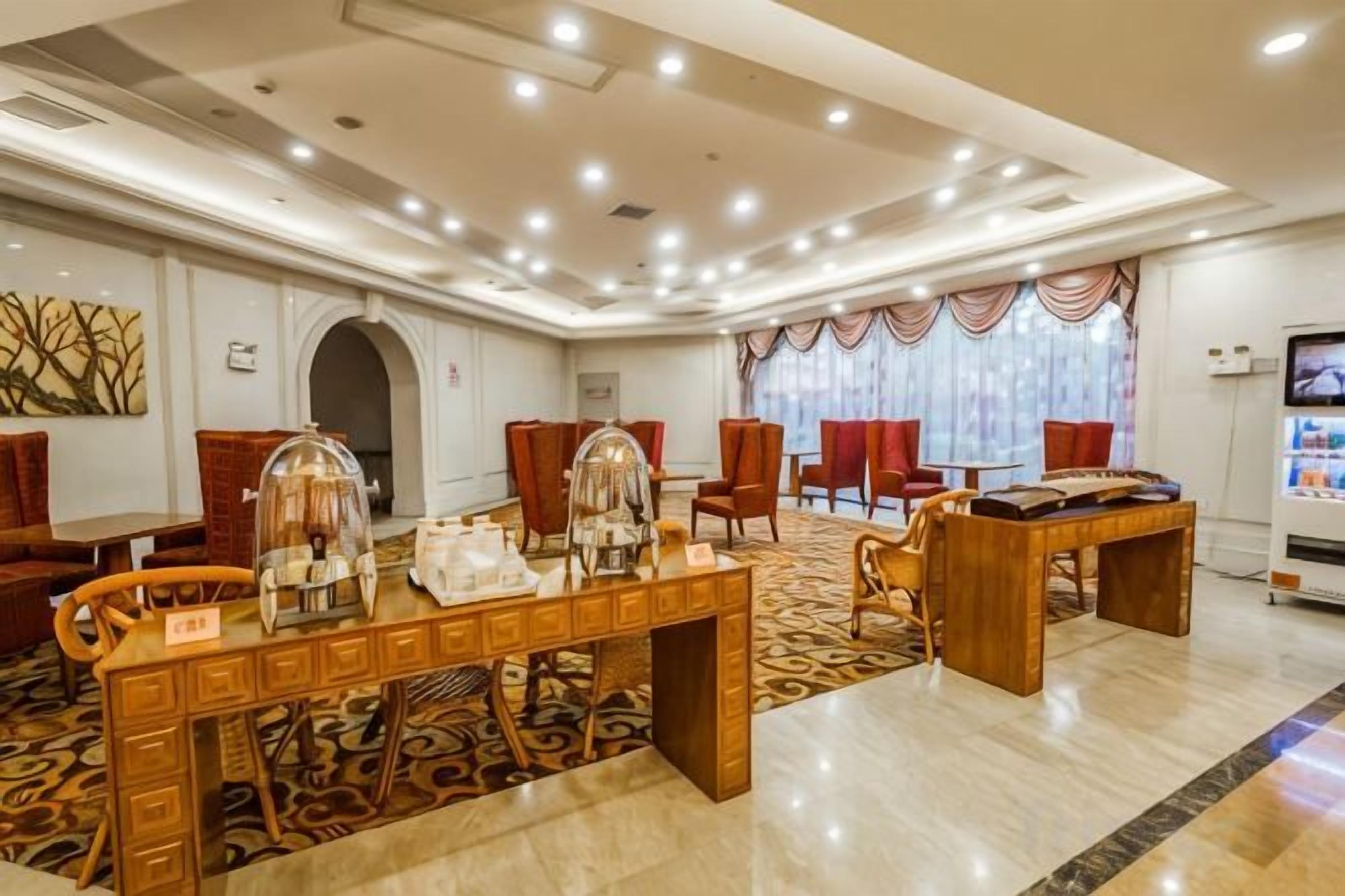 A hotel lobby with a reception desk, seating area, and a pool table.