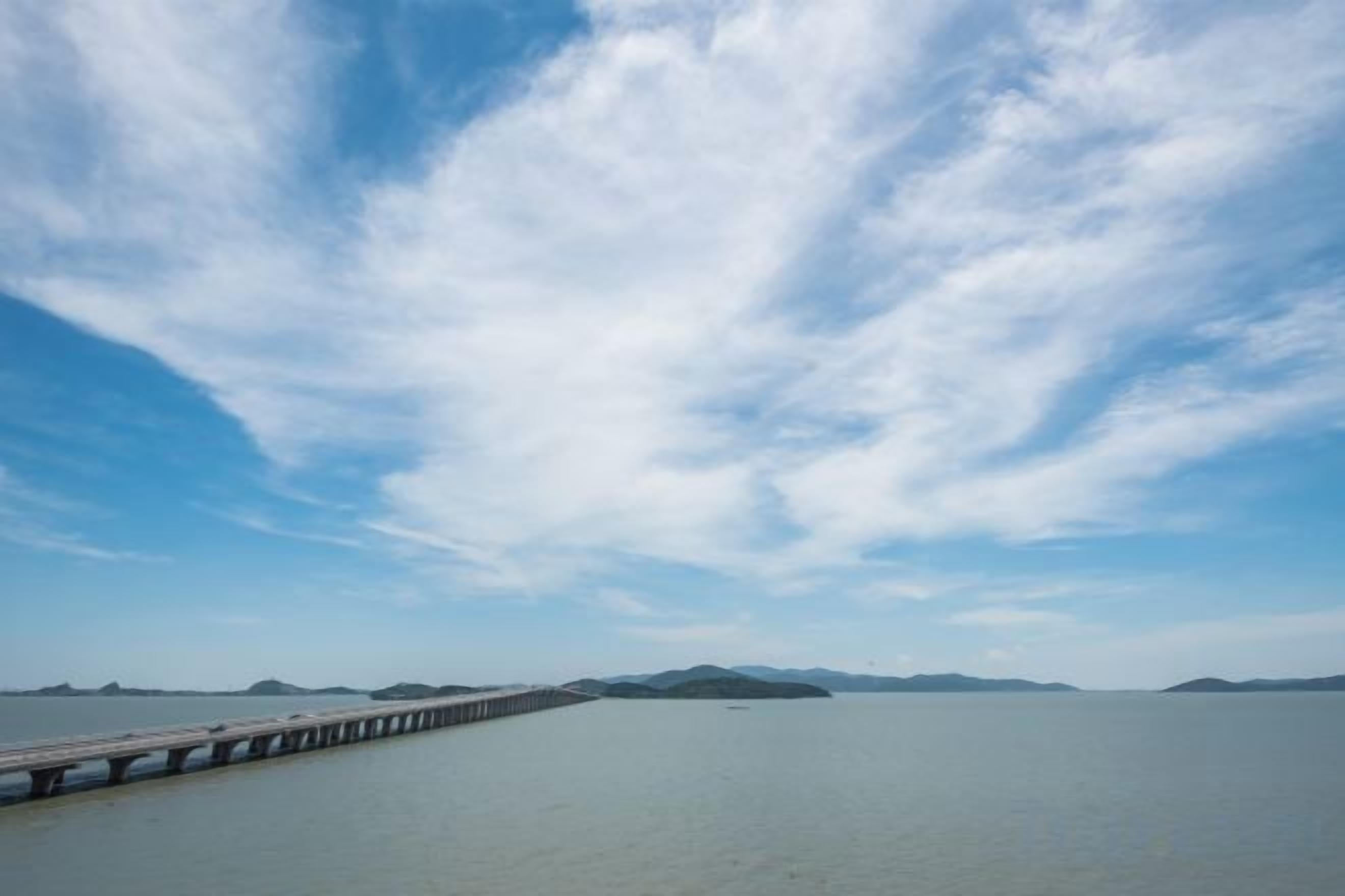 Un muelle largo que se adentra en aguas tranquilas bajo un cielo despejado.