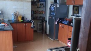 A kitchen with wooden cabinets, a refrigerator, a stove, and a microwave.