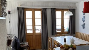 Una cocina compacta con una mesa de comedor, una pequeña isla con fruta y vistas al exterior.