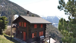 Eine Holzhütte mit geneigtem Dach, einer Holztreppe und einem Balkon.