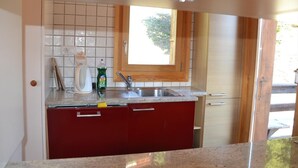Eine Küche mit Fenster, Spüle und Schränken.